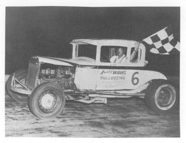 1964 - Dink Woodard with a checkered flag (Charles Eby Photo).jpg